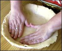 Patting the dough into the pie pan